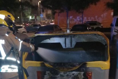 Un bomber treballant en un dels incendis de contenidors.