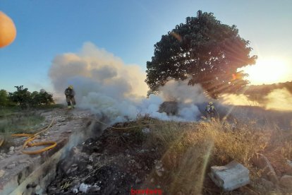 Dos bombers treballant en el foc de Masdenverge.