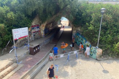 Tot i que el túnel porta tancat diversos dies, desenes de banyistes el creuen diàriament per anar a la platja.