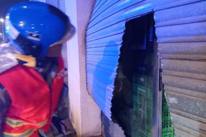 Els bombers van haver de tallar la persiana per poder accedir al local.