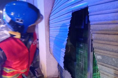 Els bombers van haver de tallar la persiana per poder accedir al local.