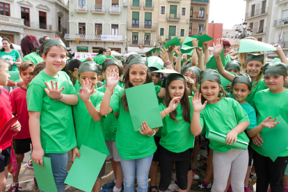 Más de un millar de niños reusenses se han reunido en el Mercado para recrear la figura del Dragón de Reus, en el acto «Hola, Sant Pere»! que da la bienvenida en las fiestas mayores.