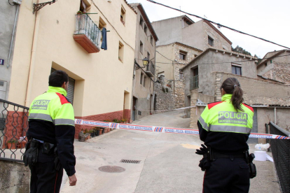 Dos agents dels Mossos d'Esquadra davant del precinte que dóna accés al carrer on vivien els veïns que s'han barallat a Arbolí.