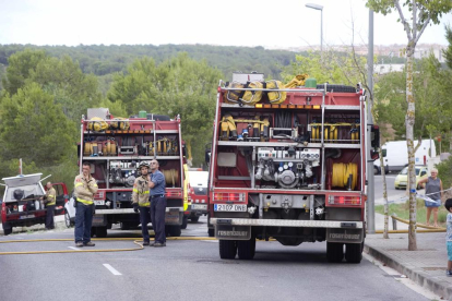 Membres del cos de bombers participant aquest dilluns en l'extinció d'un foc proper al barri.