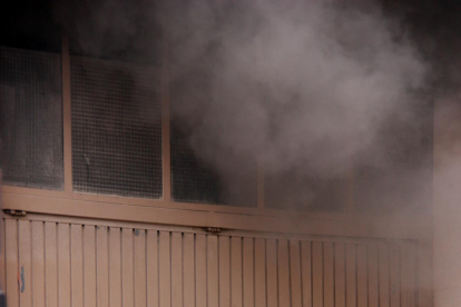 Uns bombers a l'entrada del pàrquing, comunicant-se amb els companys a l'interior de l'aparcament, mentre surt una densa fumera per un vehicle en flames, el 5 de juliol de 2016