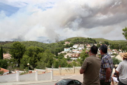 Dos veïns de La Pobla de Montornès observen i senyalen el fum i les flames de l'incendi que crema prop d'una urbanització del municipi. Imatge del 5 d'agost de 2016 (horitzontal)
