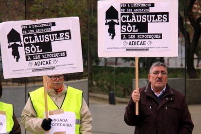 Dos membres d'Adicae amb pancartes aquest dimecres a la Ciutat de la Justícia de l'Hospitalet.
