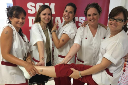 Personal sanitario de Joan XXIII mostrando los tatuajes de la campaña de donación de sangre.