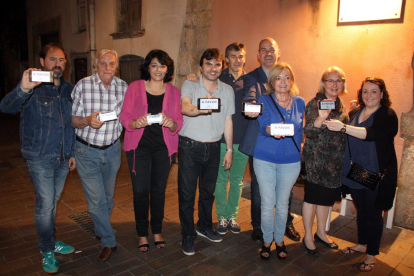 Pla general del cap de llista del PP, Jordi Roca, amb altres membres de la candidatura mostrant el lema de la seva campanya a les pantalles dels telèfons mòbils. Imatge del 10 de juny del 2016