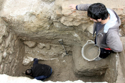Un dels arqueòlegs treballant en l'excavació d'un sot al solar de la Catedral de Tortosa, amb l'ajuda d'un company des de la superfície.