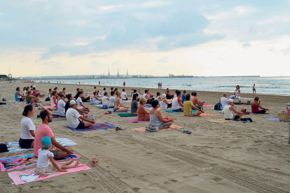 Imagen de la sesión de yoga en la playa.