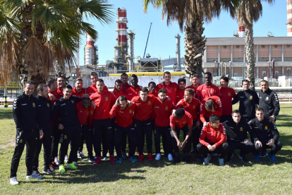 Els futbolistes i l'equip tècnic a l'exterior del complex industrial.