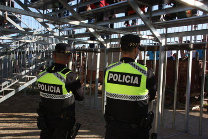 Dos agentes de la policía local de Alcanar, de espaldas, a la plaza.