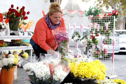 Varias personas venden flores durante Todos los Santos.