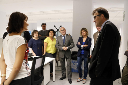 Plano medio del secretario de Hacienda, Lluís Salvadó, conversando con una trabajadora de la nueva oficina de la Agencia Tributaria de Cataluña (ATC) en Reus, el 1 de septiembre del 2017