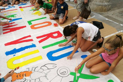 La pancarta que van pintar els nens es penjarà en un dels carrers del poble.