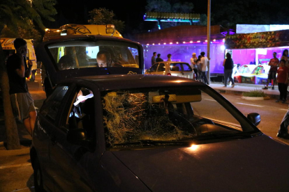 Primer pla del cotxe implicat en l'atropellament davant de la zona d'atraccions ambulants de la festa major de Roquetes, amb alguns agents dels Mossos d'Esquadra treballant a la part posterior. Imatge del 2 de juliol de 2017 (horitzontal)