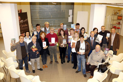 Imatge de grup d'una vintena d'escriptors, reunkts a la seu de l'editorial Pagès editors per presentar novetats per Sant Jordi