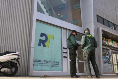 Dos agentes de la Guardia Civil en la puerta de las oficinas de Rubau y Tarrés de Girona este jueves.