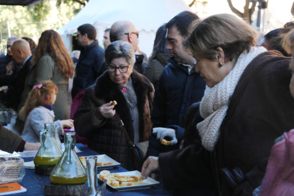 Pla tancat de diverses dones tastant oli en una parada de la Fira de l'Oli DOP Siurana a Tarragona. Imatge del 3 de desembre de 2017