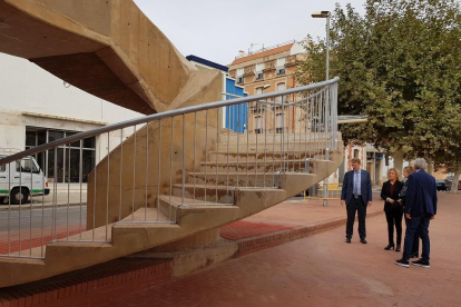 Plan abierto de la visita del alcalde de Tortosa Ferran Bel y los concejales Meritxell Roigé y Josep Felip Monclús a las escaleras de acceso al puente del Estado en el barrio de Ferreries.