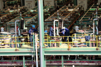Pla detall d'uns treballadors operant a la planta de clor que Ercros tancarà al desembre d'aquest any.