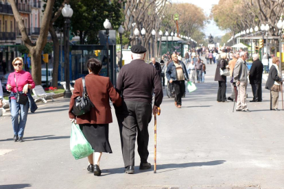 Una parella d'avis jubilats caminant pel carrer en una imatge d'arxiu.