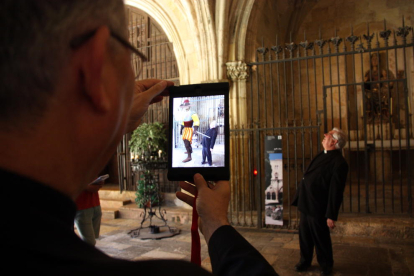 El arzobispo de Tarragona, Jaume Pujol, con el iPad en la mano, enfocando al decano-presidente del Capítulo de la Catedral de Tarragona, Joaquim Fortuny, y al lado aparece, en realidad aumentada, un caballero gigantesco de la época, Francisco Plaza