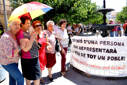 Un grupo de mujeres de Batea delante de una pancarta crítica con la propuesta del alcalde de marcharse a Aragón.
