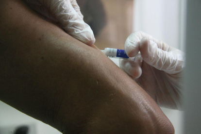 Una enfermera vacunando de gripe a un paciente en una imagen de archivo.