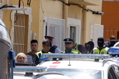 Agents dels Mossos i la Guàrdia Urbana emportant-se detinguts una dona i noi -a l'esquerra de la imatge-.