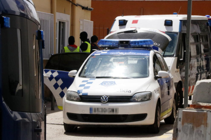 Los Mossos y la Guardia Urbana de Reus delante del domicilio donde se ha llevado a cabo un operativo antidroga, con un vehículo policial en primer término.
