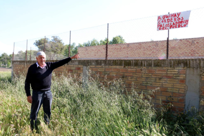 Aurelio Tena, ramader de l'Aldea, assenyalant un cartell contra els lladres que ha penjat al seu corral.