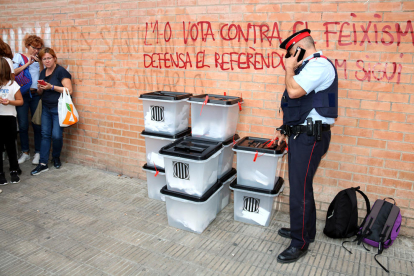 Un agentes de los Mossos inspeccionando unas urnas requisadas el 1 de octubre pasado.