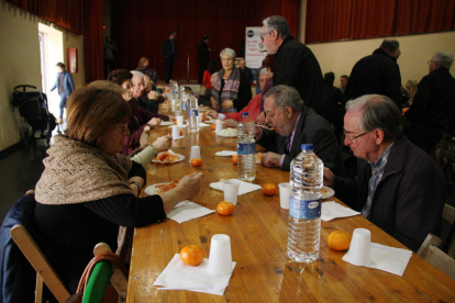 Una mesa del DiNadal con varias personas comiendo arroz blanco con tomate.