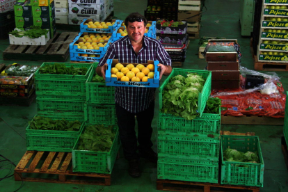 El presidente de la Cooperativa de l'Aldea, Miguel Carles, entre cajas de verduras y frutas en el almacén de la agrotienda de la entidad