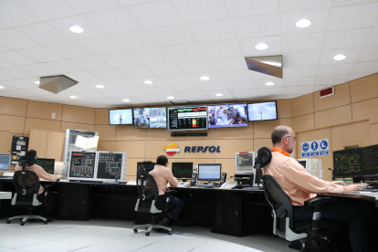 Plano general de la sala de control 24 horas de polipropileno de Repsol en Tarragona con la nueva iluminación LED que reproduce la luz natural, y de tres trabajadores en la sala, delante de las pantallas, en una imagen del 5 de mayo del 2017