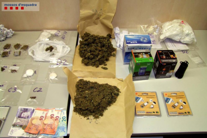 Als pisos es van localitzar una roca de cocaïna i 24 paperines amb un pes de gairebé 50 grams, un pot i diverses bossetes amb 328 grams de marihuana, gairebé 30 grams de haixix, una balança de precisió i material falsicificat, a més de diners en efectiu.