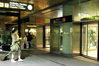 Una dona amb un mocador groc entrant a l'Aeroport de El Prat.