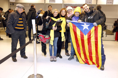 Un grup de gent amb una estelada fent cua per recollir la targeta d'embarcament a l'aeroport de Lleida-Alguaire per volar a Brussel·les.
