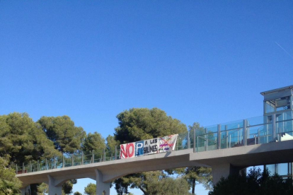 Un cartell situat al pont de l'N-340 reivindica que els veïns no volen l'aparcament a Las Salinas.