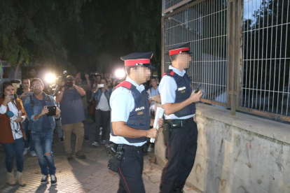 Dos agents dels Mossos que miren el recinte de l'institut Antoni Martí i Franquès de Tarragona.