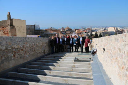 Foto de família a la zona restaurada de les muralles amb el director dels serveis territorials del Departament de Cultura, Jordi Agràs i la consellera de Patrimoni de l'Ajuntament de Tarragona, Begoña Floria.