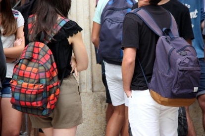 Dos adolescentes con mochilas en la espalda antes de entrar en clase.