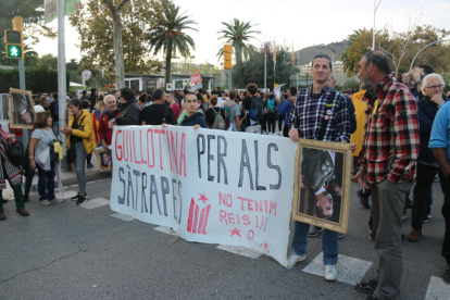 Uns manifestants aguanten una pancarta en contra de la visita del rei Felip VI a Barcelona
