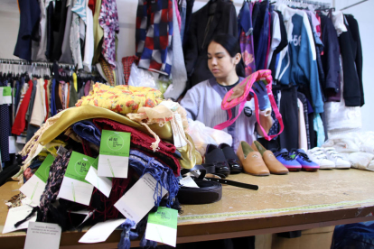 Una treballadora seleccionant la roba que es posarà a la venda a la seva botiga.