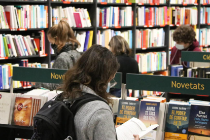 Diversos joves mirant llibres en una llibreria.