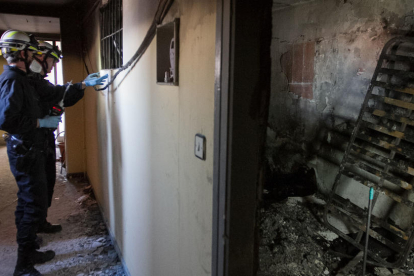 L'interior del pis de l'habitatge incendiat a Reus, amb tècnics revisant-lo.