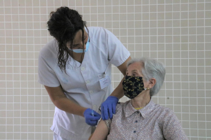 Una enfermera administrando la vacuna a una mujer en el CAP Río de Janeiro de Barcelona.