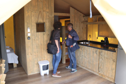 Dos personas inspeccionan el interior de uno de los alojamientos del Camping Gaviota de Creixell.